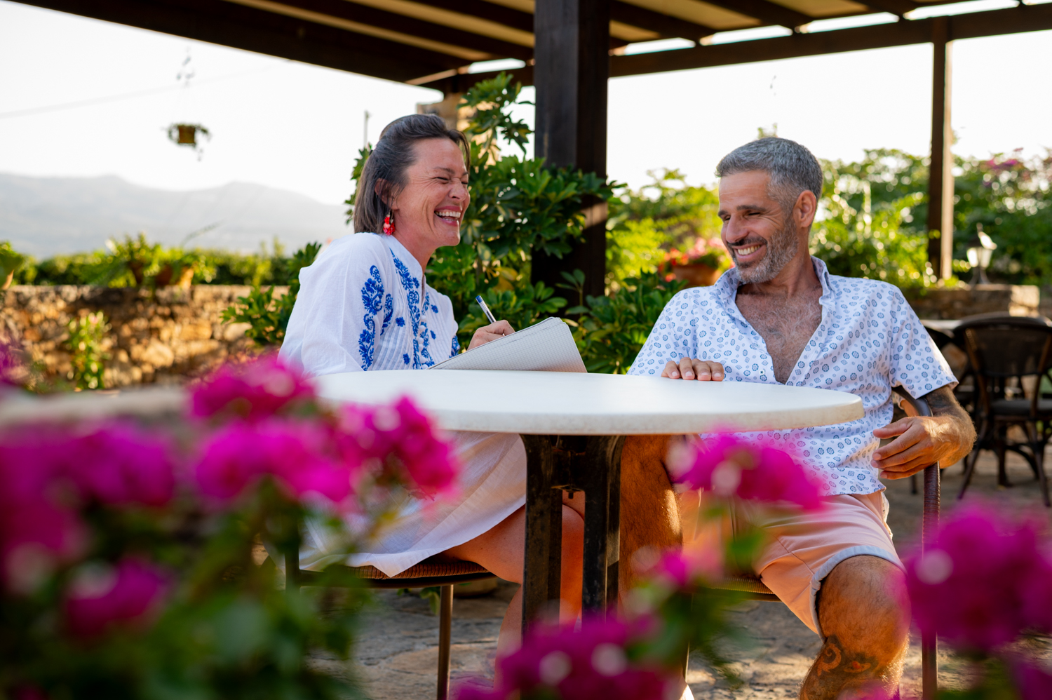Two people laughing over coffee in Crete